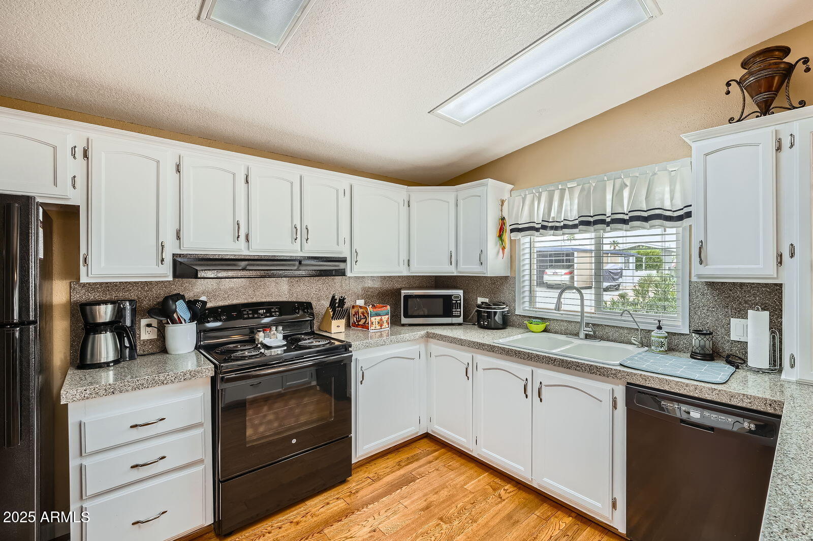 2400 East Baseline Avenue, Unit 94 Apache Junction, AZ 85119 - Photo 9 of 29 a kitchen with granite countertop a sink stainless steel appliances and cabinets