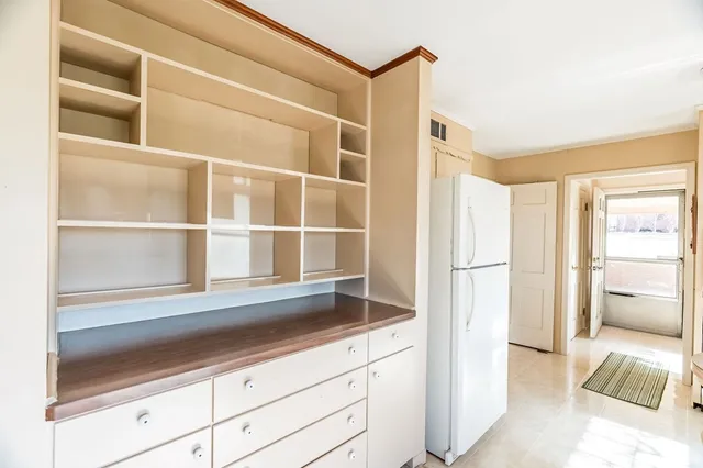 a kitchen with a refrigerator and more cabinets