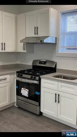 a kitchen with granite countertop white cabinets and stainless steel appliances