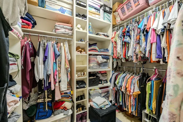a view of walk in closet with clothes