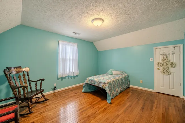 a bedroom with a bed and a chair