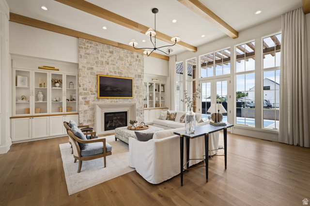 478 South Maple Lakes Drive Mapleton, UT 84664 - Photo 3 of 51 Spacious living area featuring a stone-clad fireplace with a mantel, built-in cabinetry, exposed ceiling beams, and wood-finish flooring