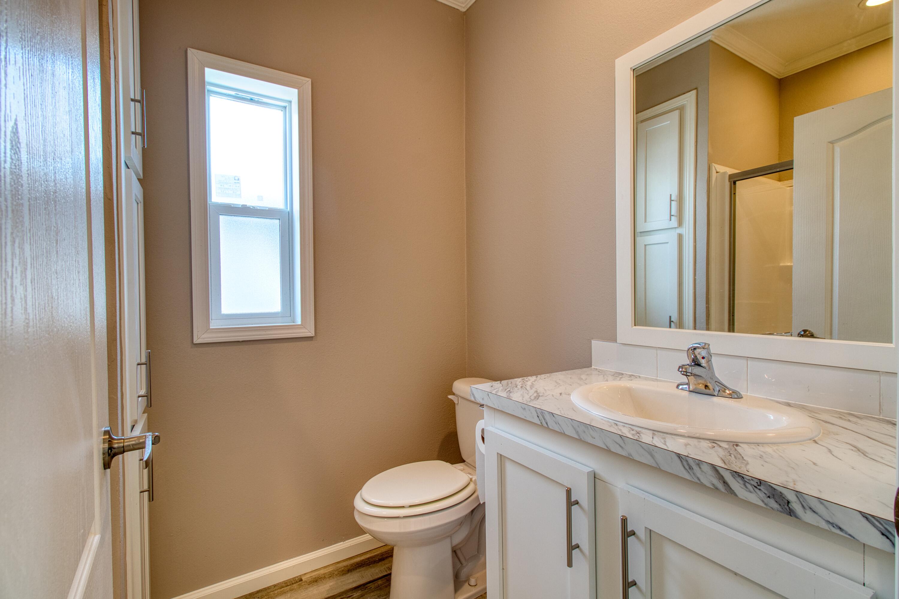 10701 South Ocean Drive, Unit 613 Jensen Beach, FL 34957 - Photo 19 of 64 a bathroom with a granite countertop sink toilet and a mirror