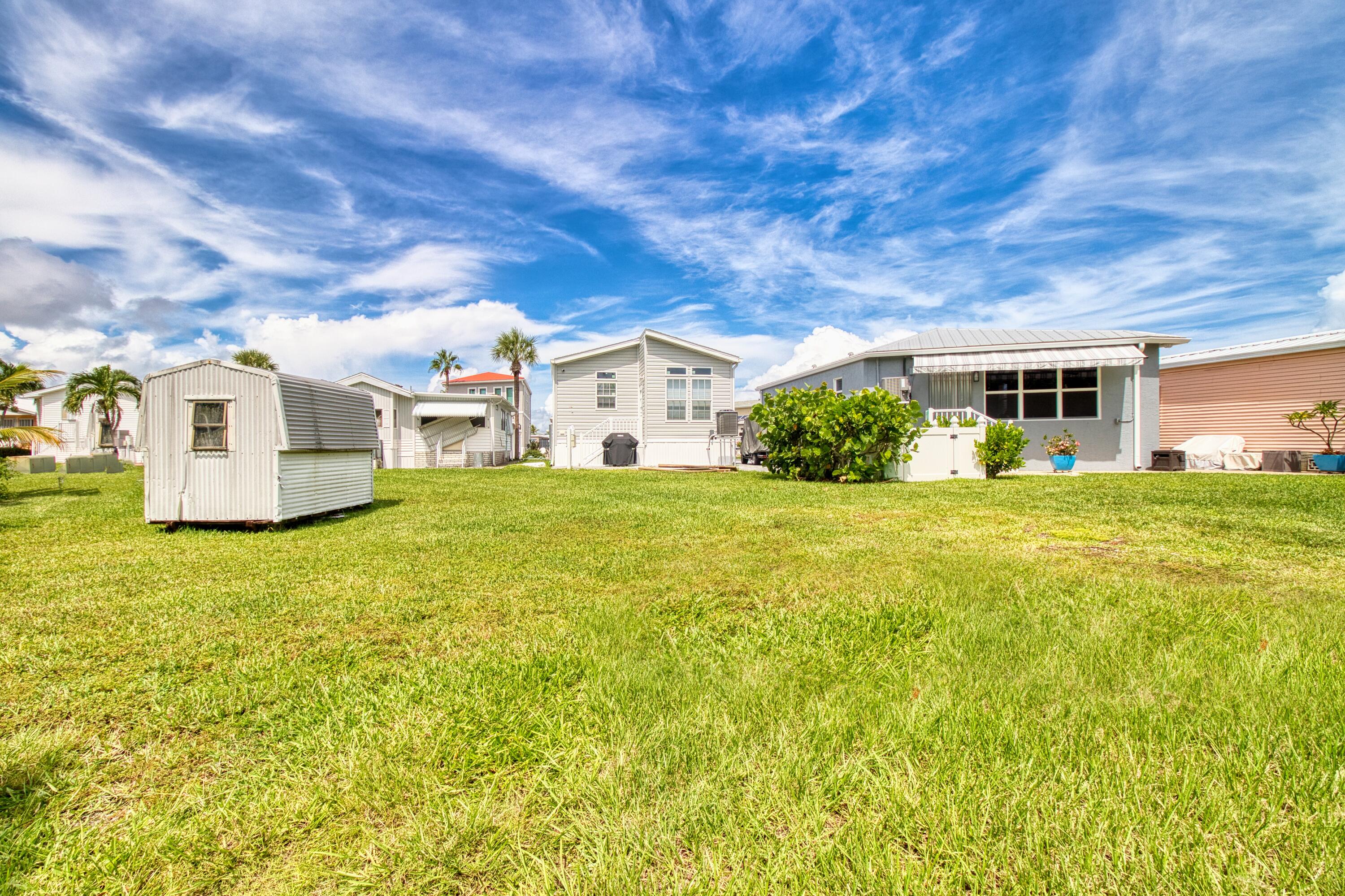 10701 South Ocean Drive, Unit 613 Jensen Beach, FL 34957 - Photo 27 of 64 a view of a white house with a big yard and potted plants
