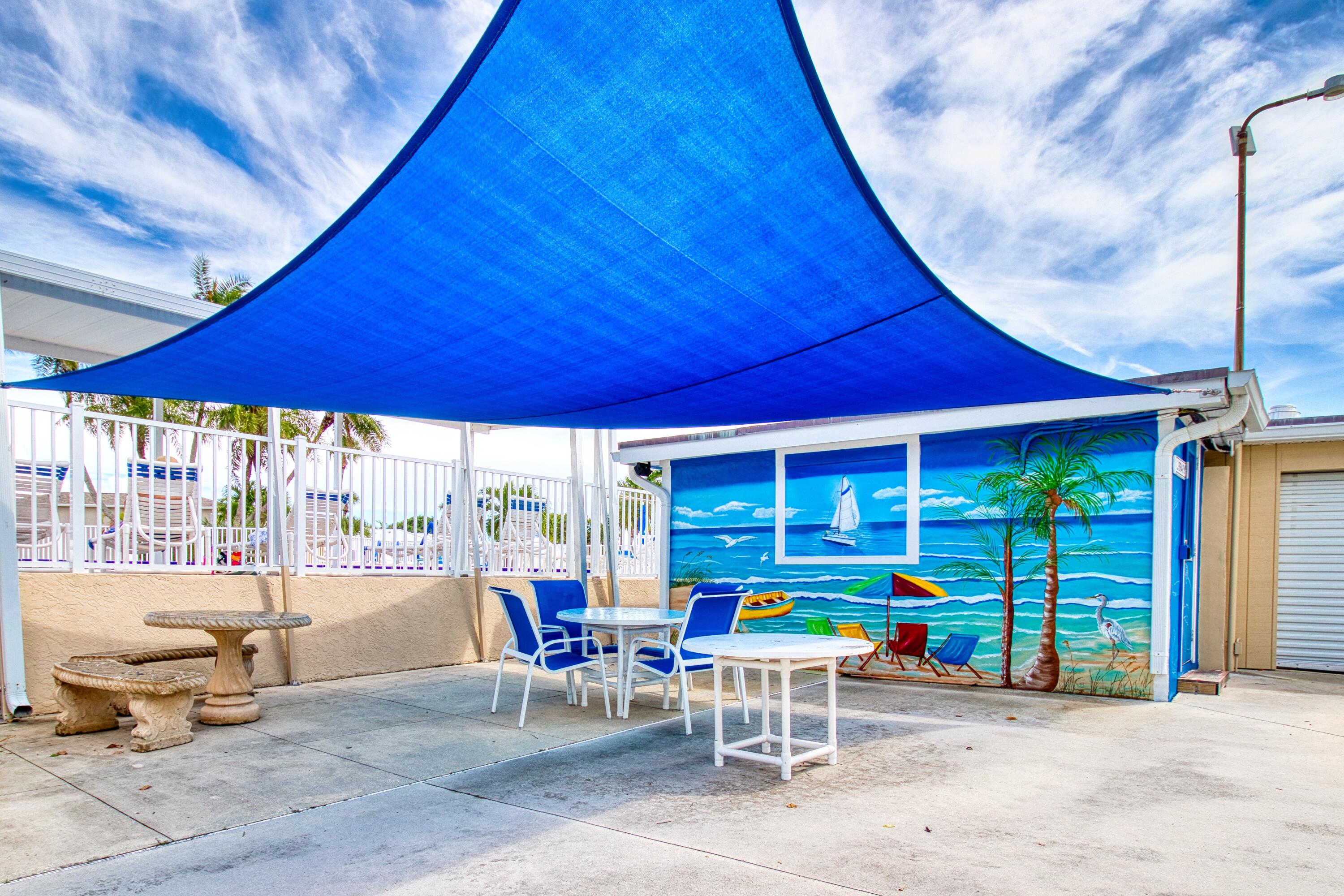 10701 South Ocean Drive, Unit 613 Jensen Beach, FL 34957 - Photo 34 of 64 a view of a patio with table and chairs under an umbrella