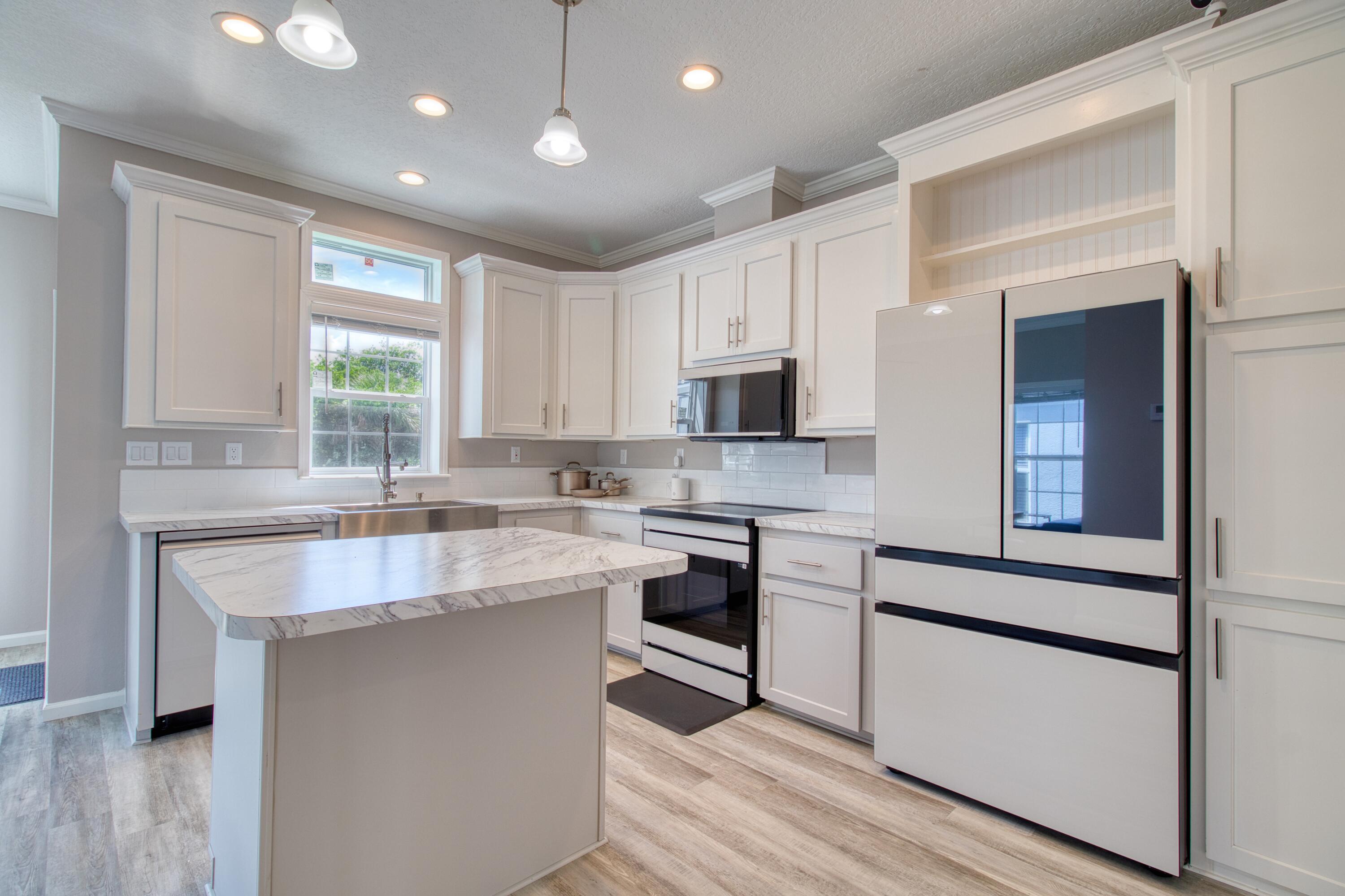 10701 South Ocean Drive, Unit 613 Jensen Beach, FL 34957 - Photo 5 of 64 a kitchen with stainless steel appliances granite countertop a sink stove and refrigerator