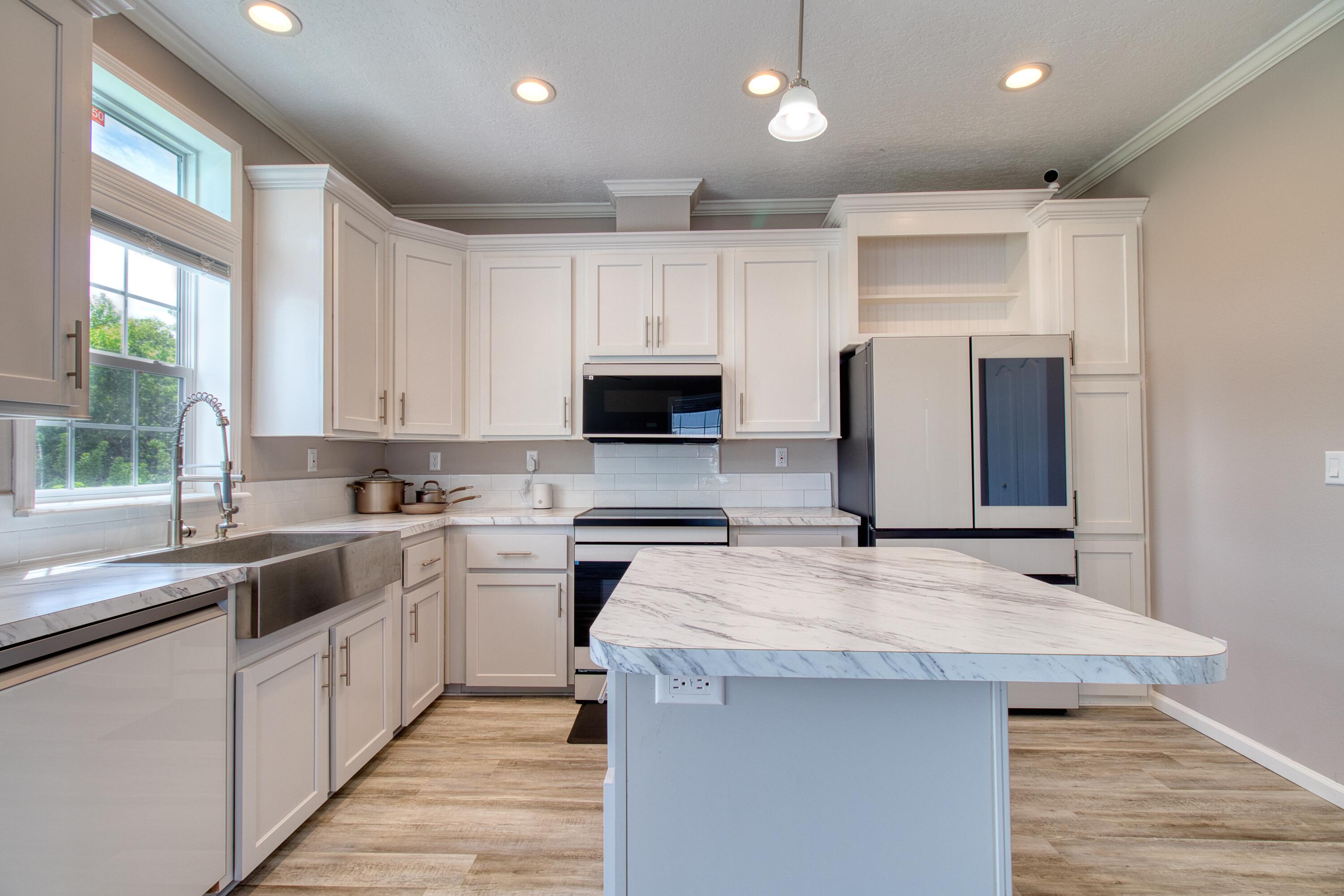 10701 South Ocean Drive, Unit 613 Jensen Beach, FL 34957 - Photo 6 of 64 a kitchen with a sink a counter top space stainless steel appliances and a window