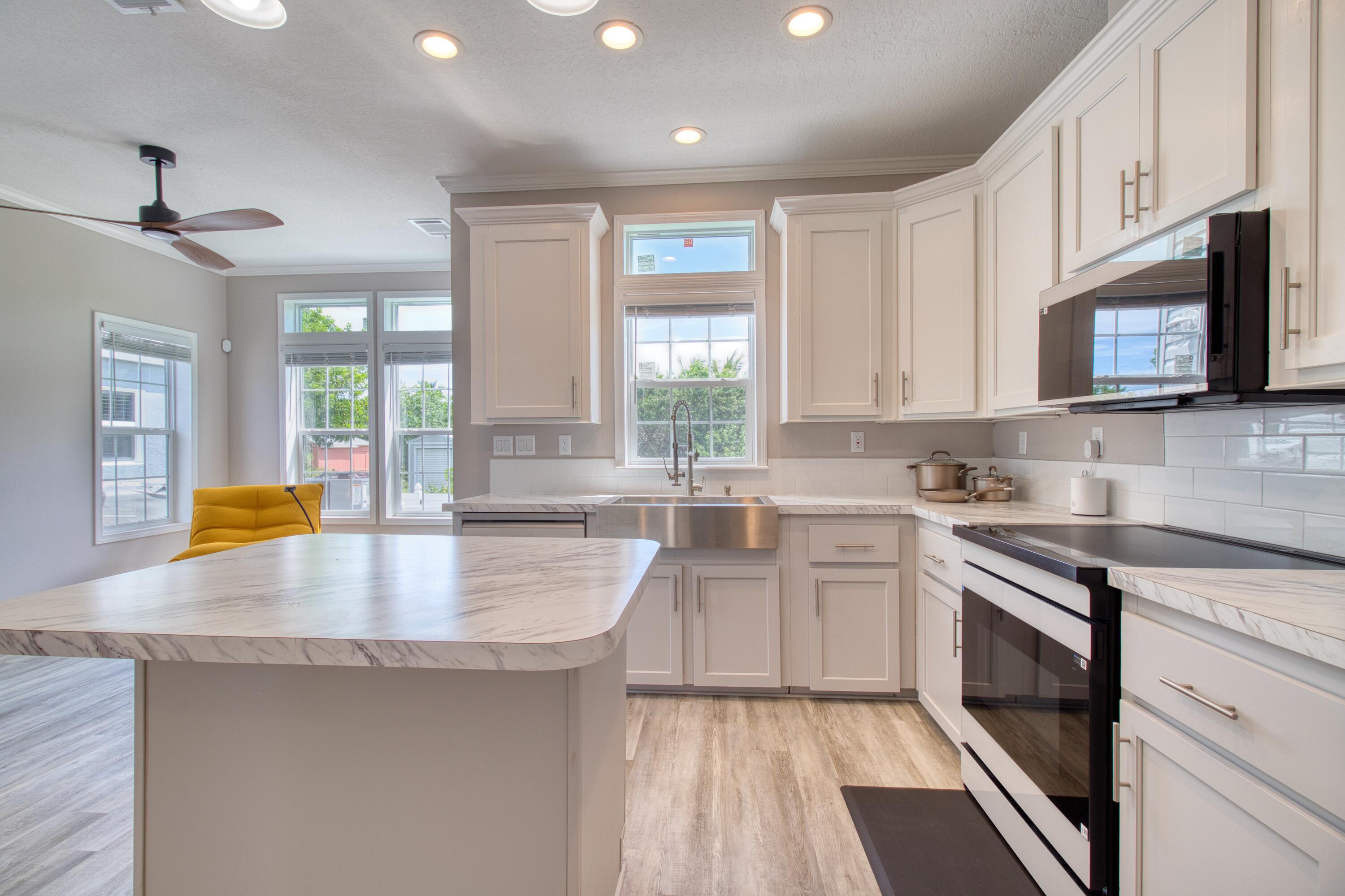 10701 South Ocean Drive, Unit 613 Jensen Beach, FL 34957 - Photo 7 of 64 a kitchen with stainless steel appliances granite countertop a stove a sink and a microwave
