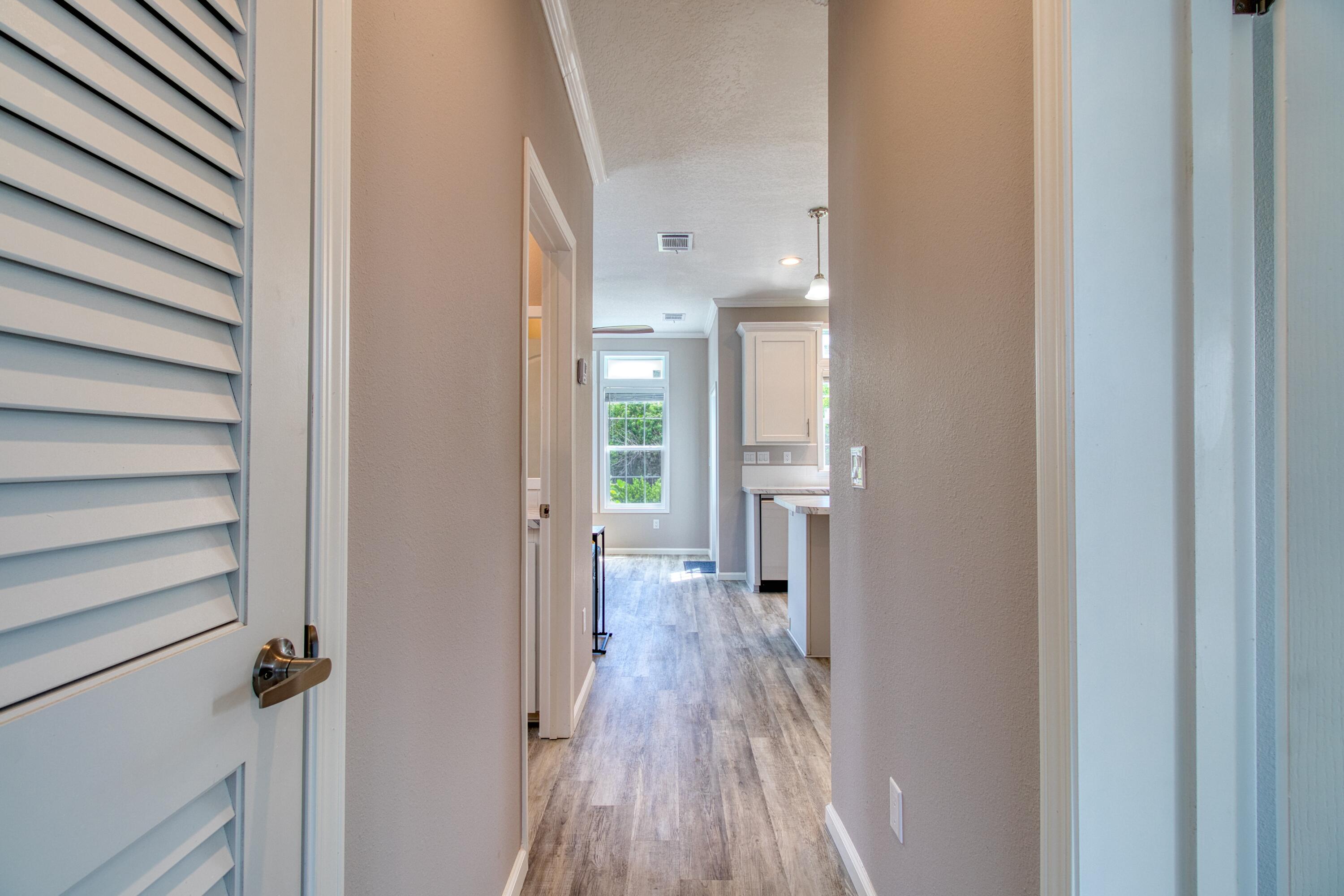 10701 South Ocean Drive, Unit 613 Jensen Beach, FL 34957 - Photo 10 of 64 a view of a hallway with wooden floor and staircase