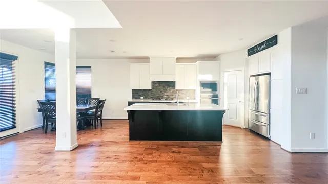 a view of kitchen with stainless steel appliances kitchen island granite countertop a refrigerator stove top oven and sink