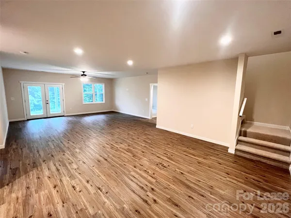 a view of an empty room with a ceiling fan and carpet