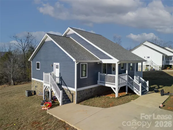 a view of a house with wooden deck front of house