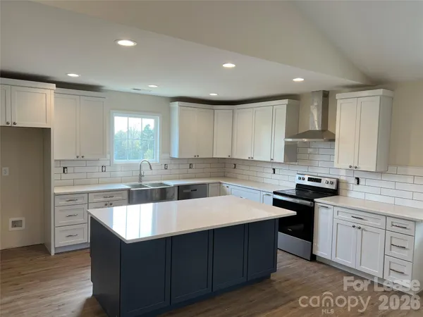 a kitchen with stainless steel appliances granite countertop a sink a stove a refrigerator and cabinets