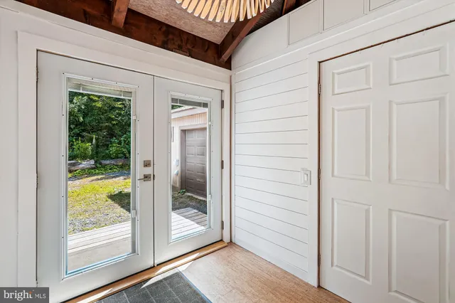 a view of a hallway with wooden floor and closet