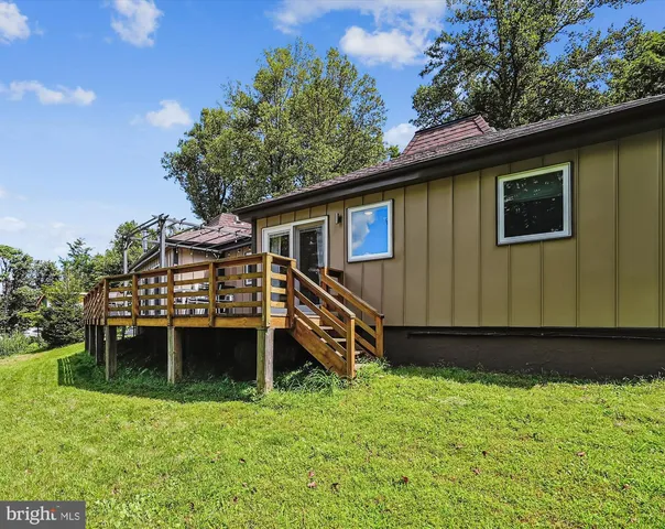 a view of a house with a yard and large trees