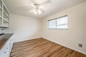 en empty room with wooden floor and fan