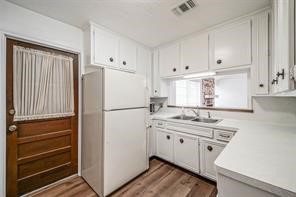 1111 Pecan Circle Seabrook, TX 77586 - Photo 8 of 31 a kitchen with a refrigerator sink stove and cabinets
