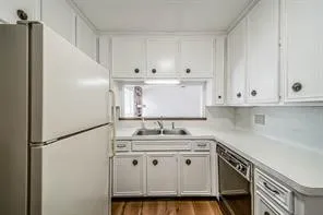 a kitchen with stainless steel appliances granite countertop white cabinets sink and refrigerator