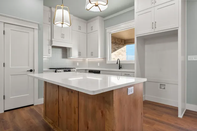 a kitchen with kitchen island a sink cabinets and wooden floor