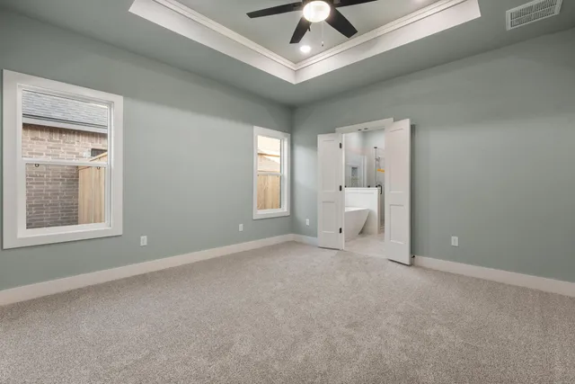 a view of an empty room with a window and a ceiling fan