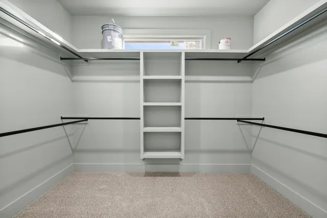 a view of walk in closet with empty racks