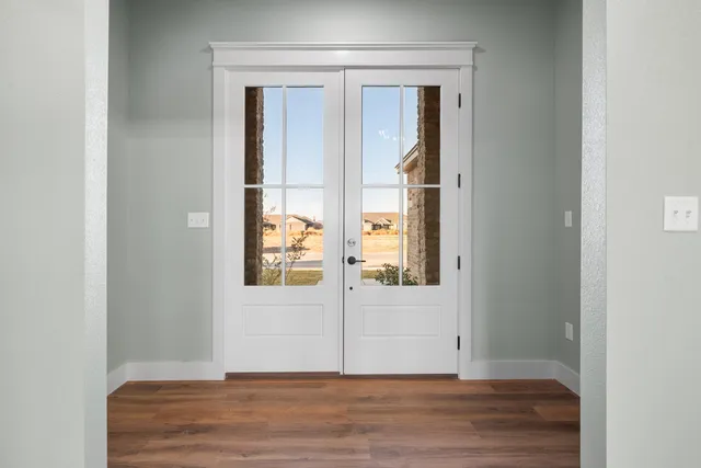 an empty room with wooden floor and mirror