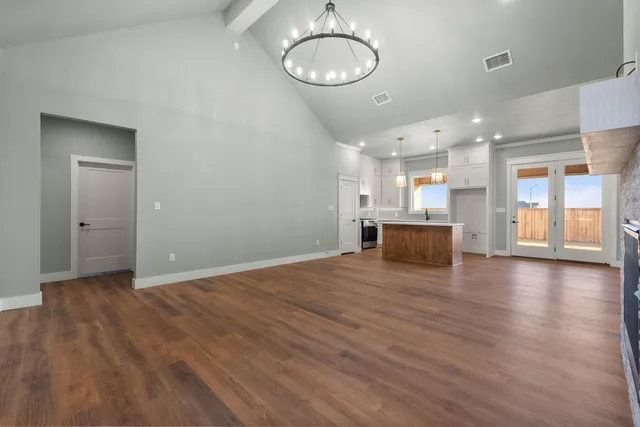 a view of a room with wooden floor and kitchen view