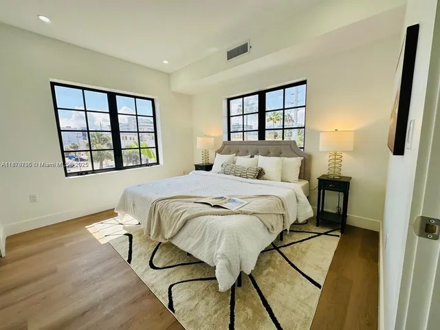 a bedroom with a bed window and a wall painting