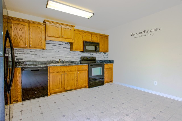 4272 J L Head Road Cedar Hill, TN 37032 - Photo 13 of 30 a kitchen with stainless steel appliances granite countertop a sink and a stove next to a cabinet