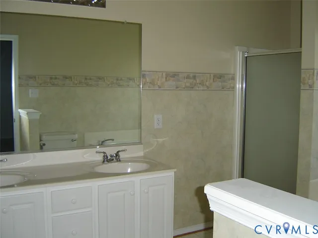 a bathroom with a granite countertop sink a toilet and a shower