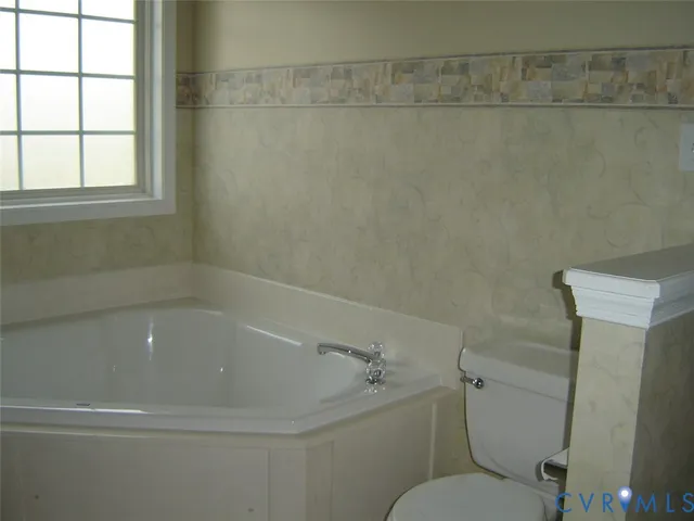 a white bath tub sitting next to a toilet