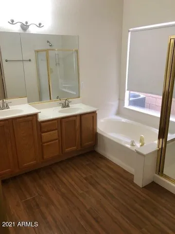 a bathroom with a tub sink and mirror
