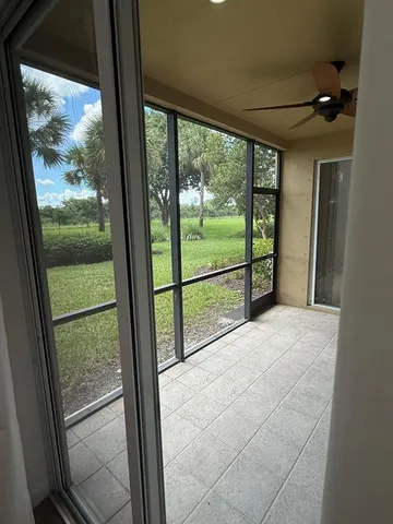 a view of a room with large windows and wooden floor