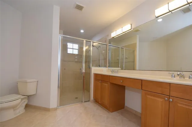 a bathroom with a double vanity sink toilet and shower