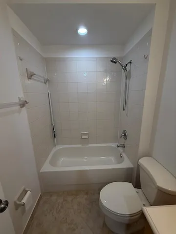 a white toilet sitting next to a bath tub