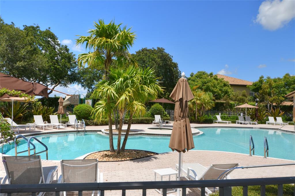8297 Northwest 128th Lane, Unit 20C Parkland, FL 33076 - Photo 33 of 42 a swimming pool with some trees in the background