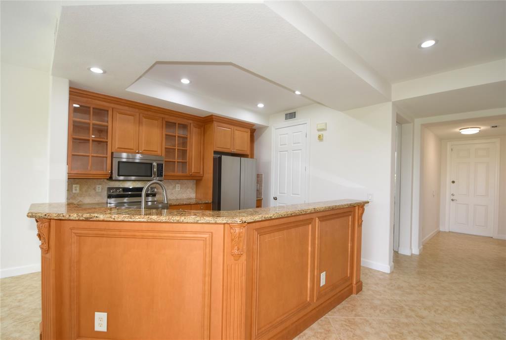 8297 Northwest 128th Lane, Unit 20C Parkland, FL 33076 - Photo 5 of 42 a kitchen with stainless steel appliances granite countertop a sink a stove and a refrigerator