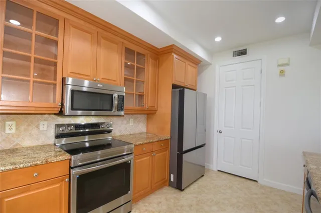 a kitchen with stainless steel appliances a refrigerator stove and microwave