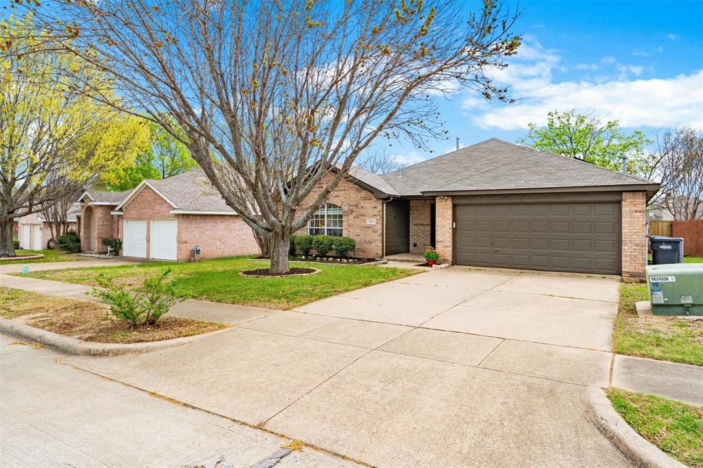 1011 Ridgecrest Drive McKinney, TX 75069 - Photo 4 of 31 Brick exterior featuring an attached two-car garage, mature landscaping, an arched front window, and a concrete driveway
