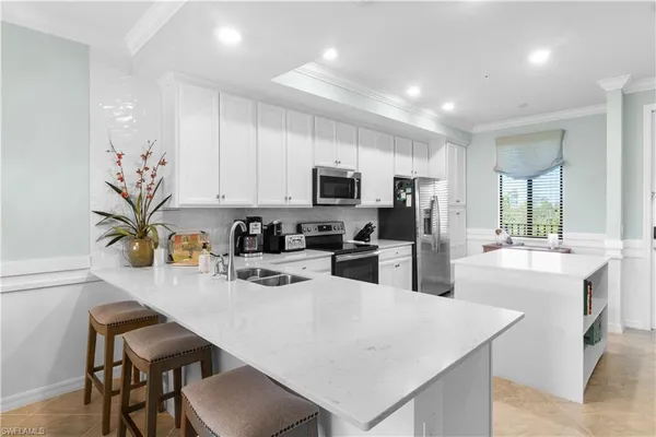 a kitchen with white cabinets and stainless steel appliances