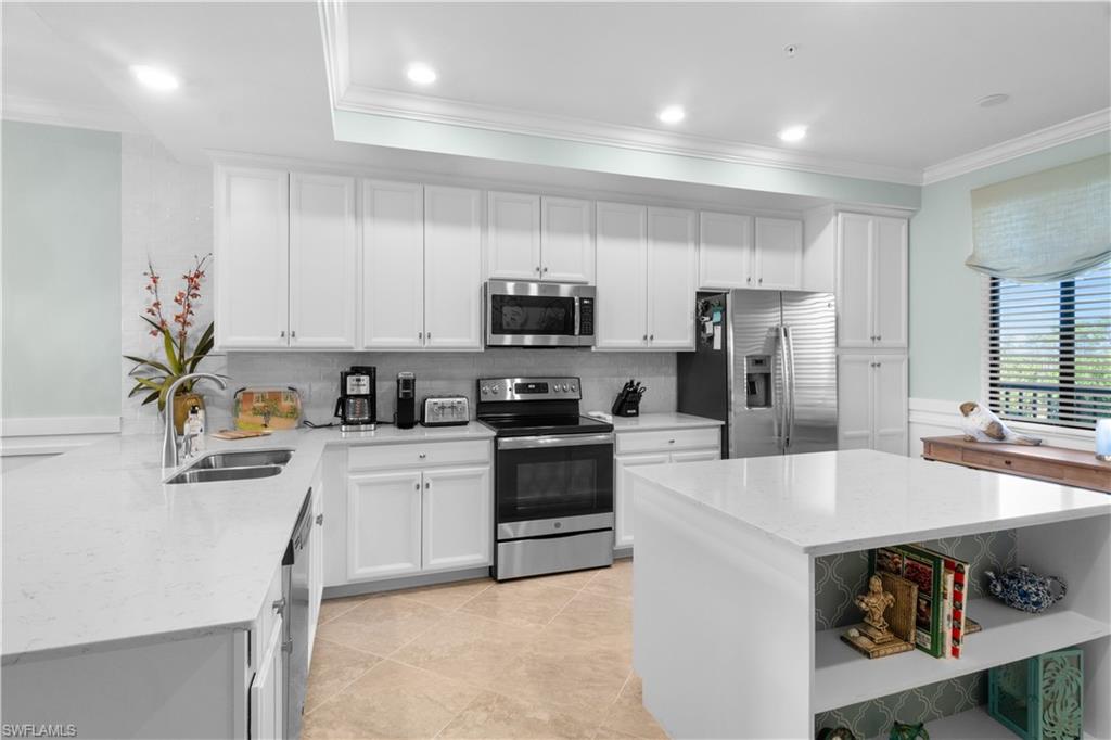 9578 Trevi Court, Unit 5135 Naples, FL 34113 - Photo 5 of 31 a kitchen with a sink a stove a refrigerator and cabinets