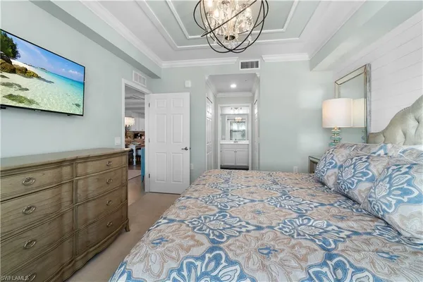 a bedroom with a large bed and a chandelier