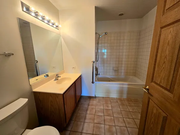 a bathroom with a sink a toilet a mirror and shower
