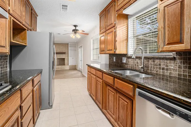 a kitchen with stainless steel appliances granite countertop a sink stove and refrigerator