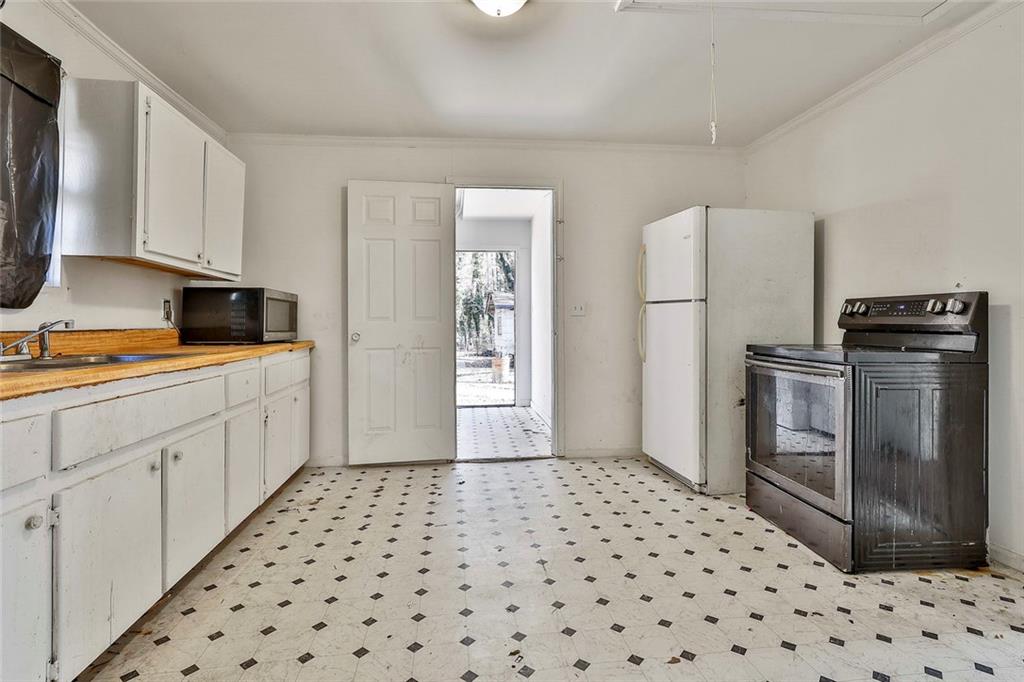66 Howell Drive Southwest Atlanta, GA 30331 - Photo 18 of 27 a kitchen with a sink a refrigerator and cabinets