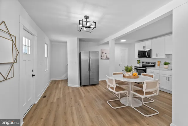 a view of a dining room with furniture a chandelier and wooden floor