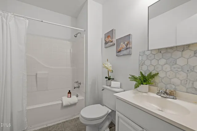 a bathroom with a sink a toilet a mirror and shower