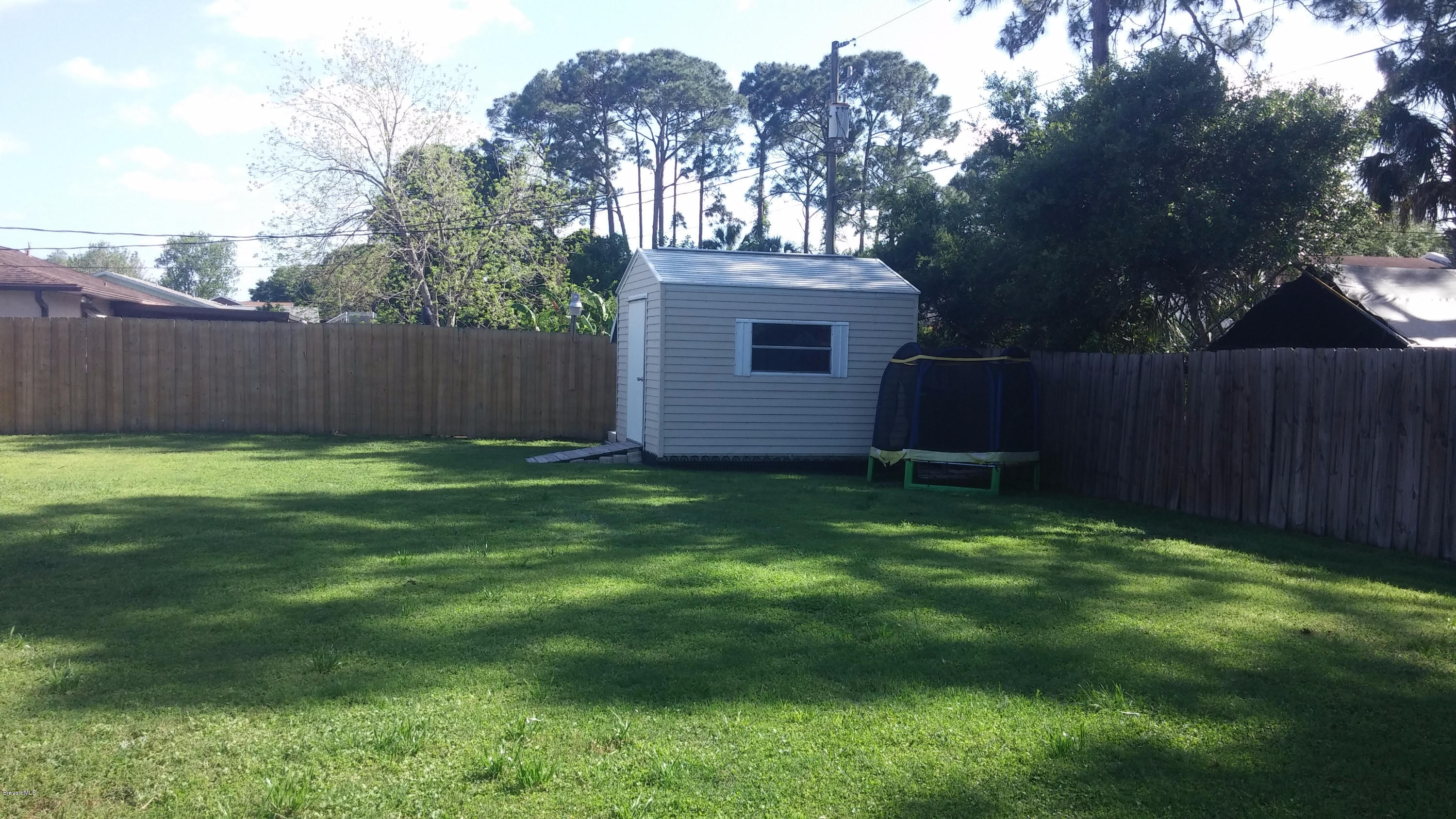 6950 Bryant Road Cocoa, FL 32927 - Photo 11 of 20 a view of backyard with potted plants and large tree