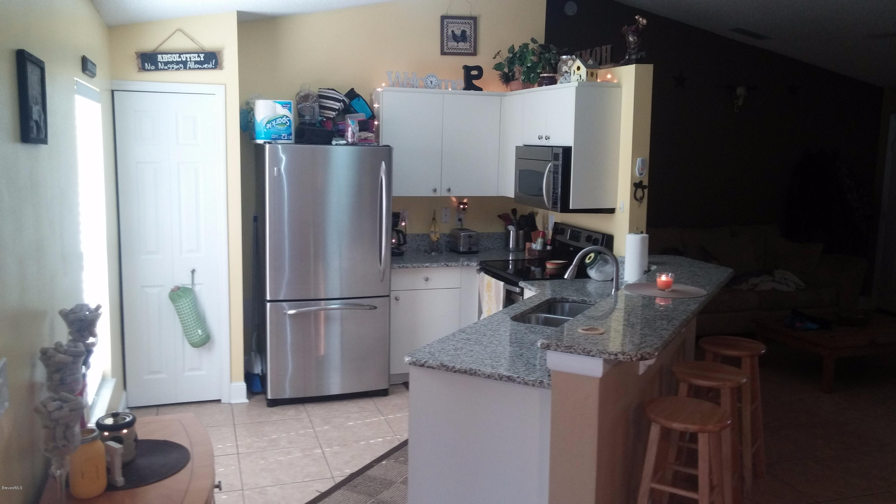 6950 Bryant Road Cocoa, FL 32927 - Photo 14 of 20 a kitchen with refrigerator and microwave