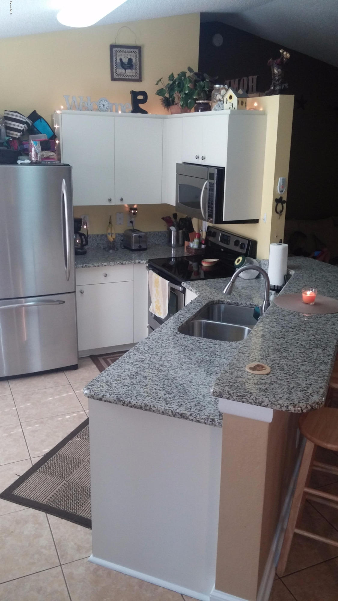 6950 Bryant Road Cocoa, FL 32927 - Photo 15 of 20 a kitchen with stainless steel appliances granite countertop a sink and a refrigerator